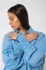 Camisa oversize color fucsia, de lino, con cuello camisero, cierre frontal con botones y mangas largas abullonadas con puños elásticos.