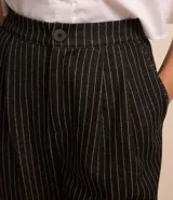 Pantalón jogger de poliéster, viscosa y elastano, con cintura de sastrería, cierre con botón y cremallera, pliegues delanteros, bajo plegado y estampa de raya de tiza.