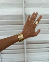 Brazalete rígido de diseño artesanal con textura irregular y acabado metálico, elaborado en bronce macizo.