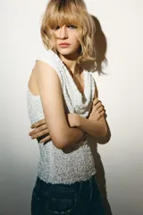 Top blanco sin mangas con escote drapeado y lentejuelas.