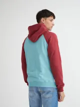 Canguro negro y ocre con capucha y cuello en rib, manga raglán, bolsillos laterales y estampa combinada (estampa y bordado).