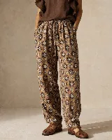 Pantalón de calce relajado y pierna amplia, confeccionado en algodón estampado con diseño geométrico en tonos marrón, tostado y blanco. Cuenta con cintura elastizada con cordón ajustable, bolsillos laterales y detalle de botón en el ruedo para regular la botamanga.