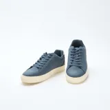 Zapatillas bajas de gamuza azul con cordones y suela de goma color crema.