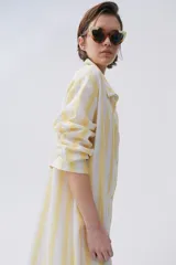 Camisa celeste y blanca a rayas verticales, de calce holgado y hombro caído, con botones al frente.