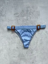 Bottom de bikini vedetina celeste con hebillas decorativas en carey.
