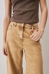 Jeans de corte barrel en color tostado, con diseño de perneras curvadas y costuras pespunteadas.