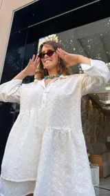 Vestido corto blanco con bordado calado, corte holgado, cuello camisero y mangas 3/4 con volados.