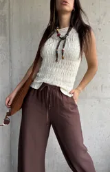 Blusa de punto sin mangas en color natural, con textura fruncida en todo el diseño y cuello redondo.