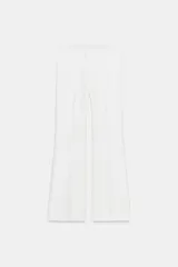Pantalón blanco de tiro alto, corte flare y cintura elástica.