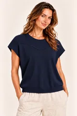 Remera de punto azul marino, de manga corta con hombros caídos, cuello redondo y detalles acanalados en canesú y hombros.