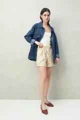 Short color beige con estampado de hojas en verde, cintura elastizada con cordón ajustable y bolsillos delanteros.