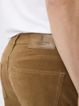 Pantalon de pana color tostado, de corte regular fit, con cinco bolsillos clásicos, cierre de botón y cremallera.