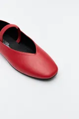 Balerina negra de cuero sintético con punta redondeada, escote en V y tira elástica sobre el empeine.