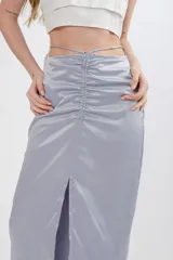 Falda midi de seda negra, con tajo frontal y cintura ajustable con cordón.