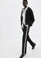 Pantalón negro de corte recto con franjas blancas laterales a lo largo de las piernas.
