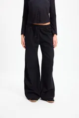 Pantalón de jean negro de corte recto y pierna ancha, con cintura elástica ajustable mediante cordón. Presenta costuras en contraste color cobre.