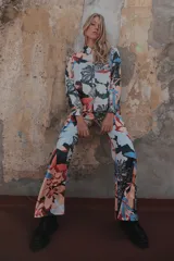 Pantalón palazzo de crepe de seda estampado con motivos florales en tonos fucsia, rojo y blanco. Tiene cierre invisible lateral y costura francesa.