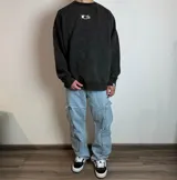 Buzo negro de corte oversize con estampado de recuadros con diseños de plantas en la espalda.