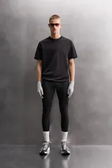 Camiseta de entrenamiento de ajuste relajado, color vino tinto, confeccionada en tejido de peso medio con mezcla de algodón. Presenta cuello redondo con acabado en vivo doble y manga corta.