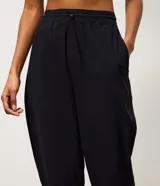 Pantalón jogger deportivo de microfibra, color tostado, con cintura elástica ajustable y puños elásticos en los tobillos. Diseño funcional y liviano, ideal para actividades físicas.