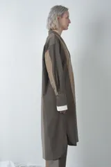 Tapado largo marrón con diseño texturizado, cuello camisero, abotonadura frontal y tajos laterales.
