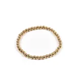 Pulsera elástica dorada con cuentas redondas.