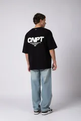 Remera oversize negra de manga corta, con cuello redondo y pequeño estampado frontal con las letras "CNPT".