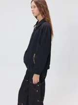 Buzo de algodón con cuello alto y cierre frontal parcial. Presenta bolsillos laterales con cierre y cuello con interior en contraste. Diseño de corte oversize.