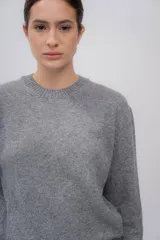 Sweater gris de tejido de punto, con cuello redondo y mangas largas.