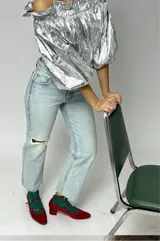 Blusa plateada con escote off-shoulder y mangas 3/4 abullonadas con elástico en los puños.