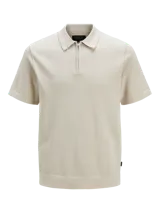 Polo de punto color beige con cuello polo, cierre frontal parcial con cremallera y mangas cortas. Presenta un tejido estructurado y corte regular.