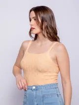 Top sin mangas ajustado al cuerpo, color naranja pálido, con tirantes finos y tejido de punto con tramado texturizado.