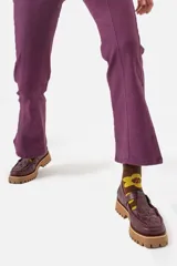 Mocasines de cuero color borgoña con detalle de tejido trenzado en la parte delantera, hebilla metálica y suela track color caramelo.