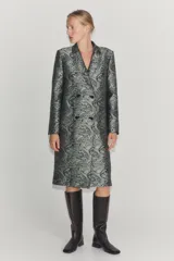 Bota de piel color marrón oscuro, de caña alta, con detalle de pespuntes en el cuerpo, tacón medio en bloque y punta cuadrada.