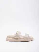 Sandalia baja de símil cuero color beige claro, con dos tiras anchas y plataforma gruesa.
