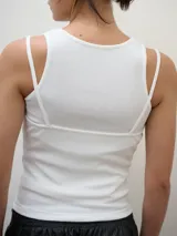 Musculosa de breteles finos con escote recto, confeccionada en tejido suave y elástico que se adapta a la silueta.