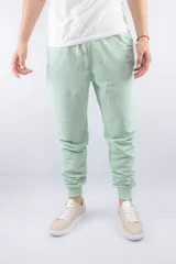 Pantalón jogger verde claro con puños ajustados y cordón en la cintura.