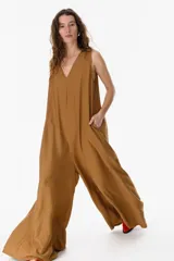 Mono largo color beige, de corte amplio y sin mangas, con escote en V.