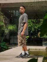 Remera de jersey color gris oscuro con efecto lavado, corte holgado y cuello redondo. Presenta un pequeño logo estampado en el pecho y un estampado grande en la espalda.