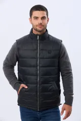 Chaleco reversible acolchado con diseño capitoneado. Un lado presenta un acabado en color beige con cierre frontal y bolsillo vertical en el pecho, mientras que el otro lado es de color azul marino. Cuenta con cuello alto y relleno térmico para mayor abrigo.