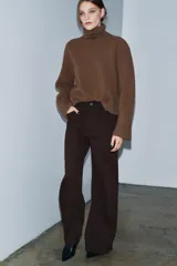 Jeans de tiro alto con corte wide leg y largo completo. Presenta diseño de cinco bolsillos, trabillas en la cintura y cierre frontal con cremallera y botón, con un acabado de efecto lavado.