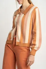 Cárdigan tejido con cierre frontal, diseño a rayas horizontales en tonos naranja, beige y rosa, cuello tipo polo y mangas abullonadas.