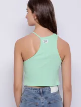 Top corto blanco de punto, sin mangas, con cuello halter asimétrico.