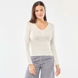 Camiseta de pijama de manga larga en color blanco, confeccionada en tejido de punto calado con textura sutil. Presenta un escote en V con borde delicado y una pequeña tapeta frontal con botones.
