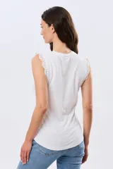 Musculosa de algodón color azul con detalles de broderie calado en los hombros, de cuello redondo y corte clásico.
