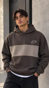 Hoodie de algodón rústico marrón con una franja horizontal central en tono tostado y un pequeño logo bordado en el pecho.