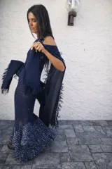 Chal de tejido liviano con terminaciones desflecadas en los bordes, ideal para usar como capa o accesorio versátil.