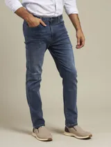 Pantalón de jean azul medio, corte slim fit, con bolsillos delanteros y traseros.