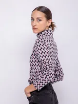 Polera negra con estampado geométrico en blanco, de cuello alto y manga larga.