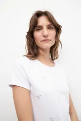 Remera blanca de algodón con cuello redondo y strass plateados formando pequeños dibujos.